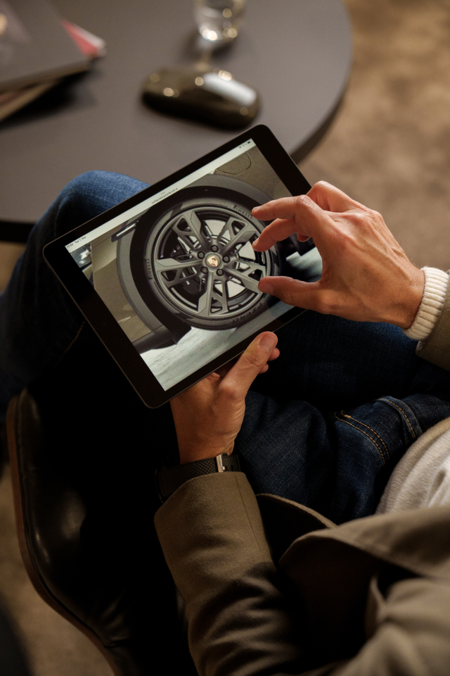 Michael Mauer using the Porsche configurator on a tablet to have a look at the wheels